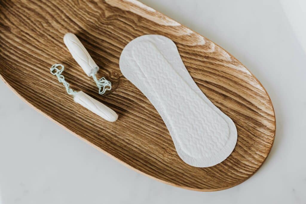 tampons et serviette hygiéniques dans une coupelle en bois