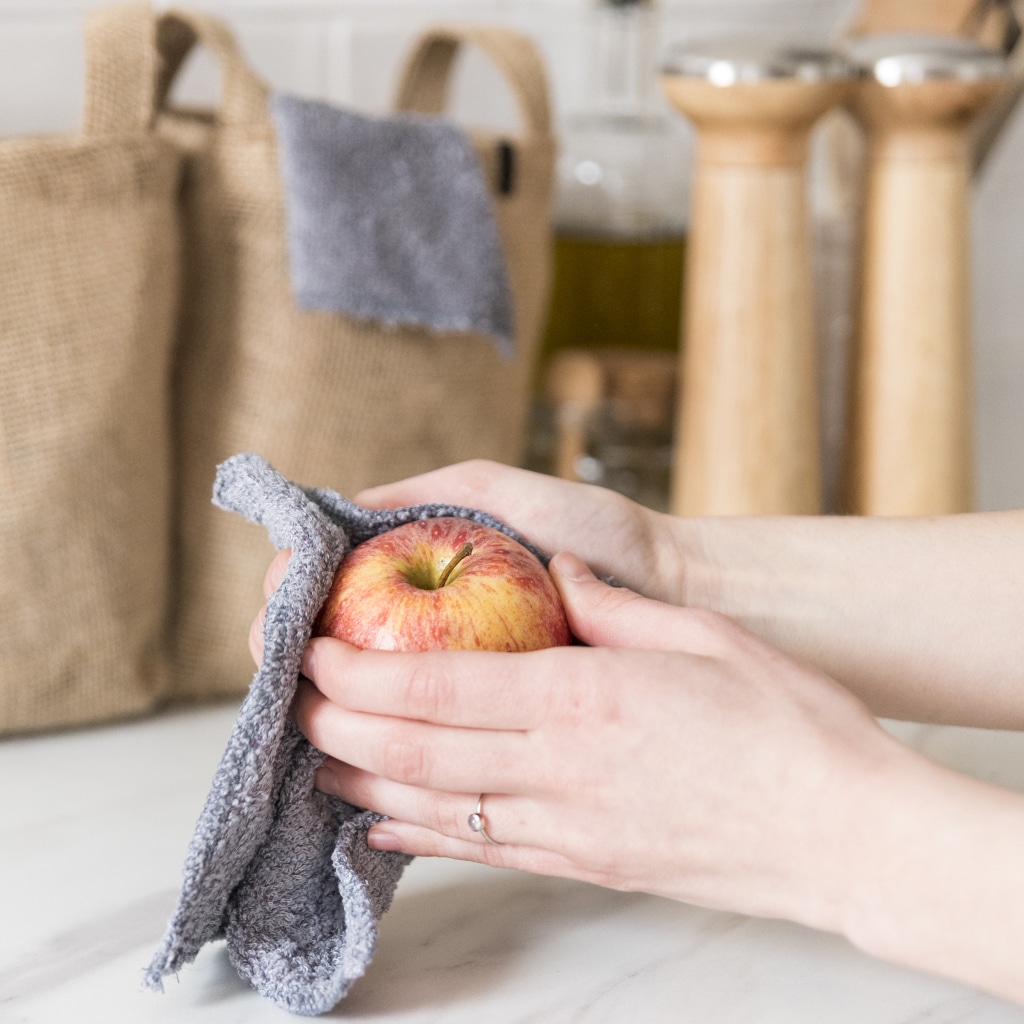 Essuie-tout lavable ManaMani utilisé pour sécher une pomme dans la cuisine