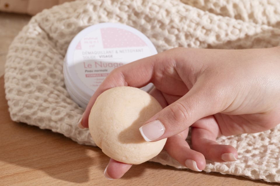 Démaquillant solide Le Nuage ManaMani tenu en main dans une routine de salle de bain zéro déchet